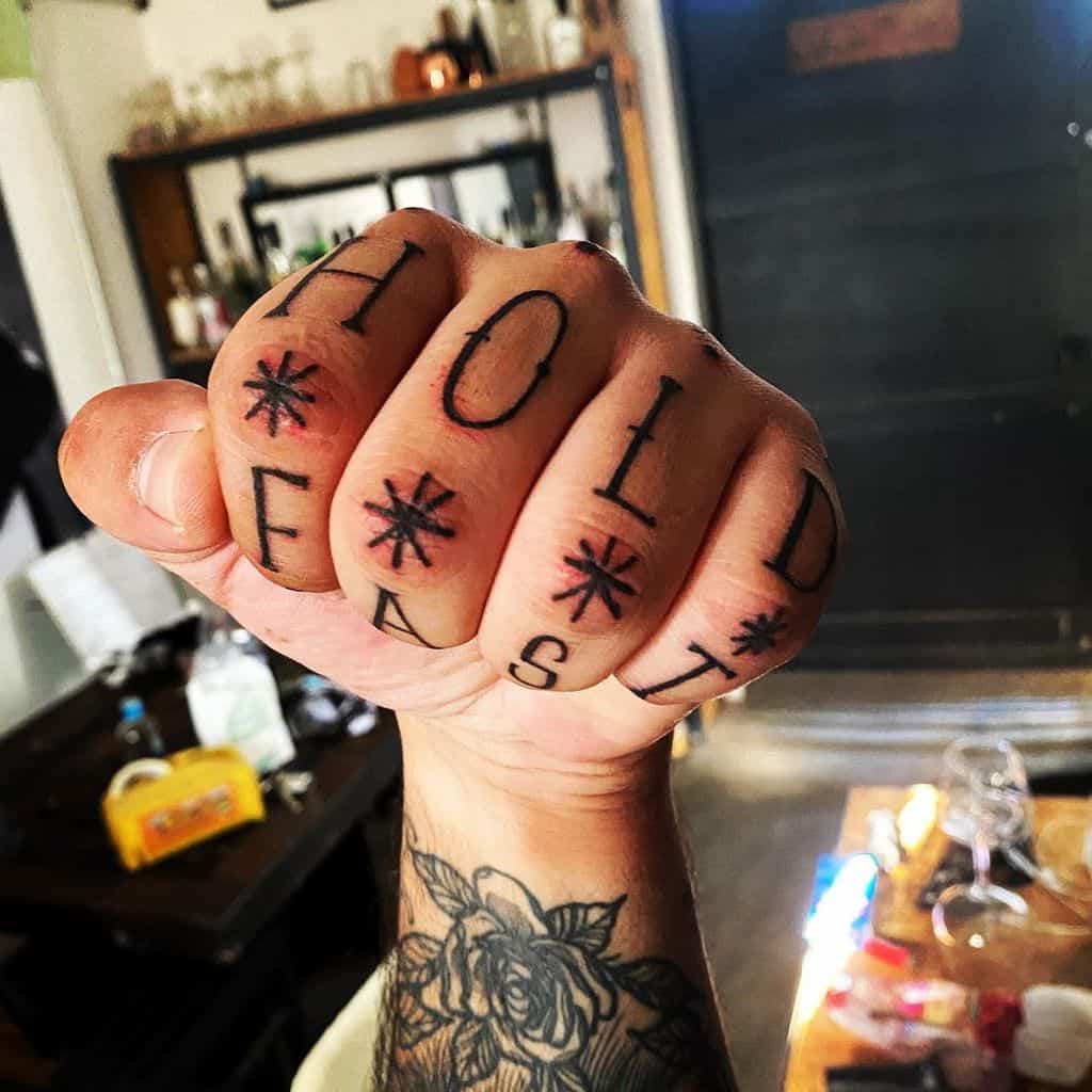 Fist with "HOLD FAST" tattooed on fingers