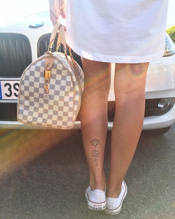 Unalome tattoo with a lotus on the calf, symbolizing spiritual enlightenment, growth, and the journey toward inner peace.