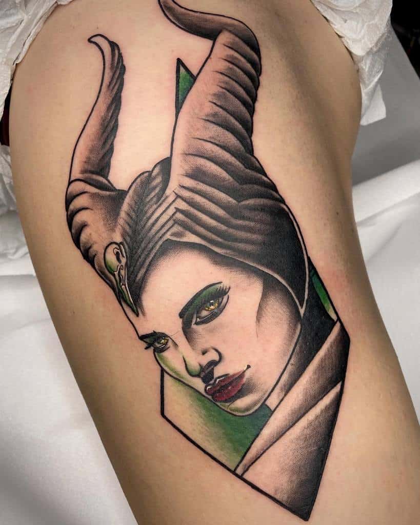 A tattoo of Maleficent with green eyes and red lips on an arm