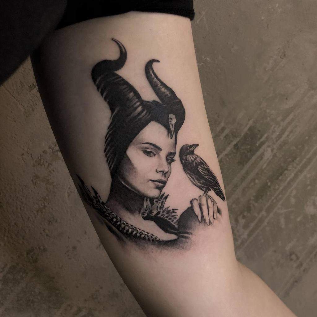 Maleficent tattoo with lifelike details featuring her signature horns and her loyal raven, capturing an enigmatic and powerful aura