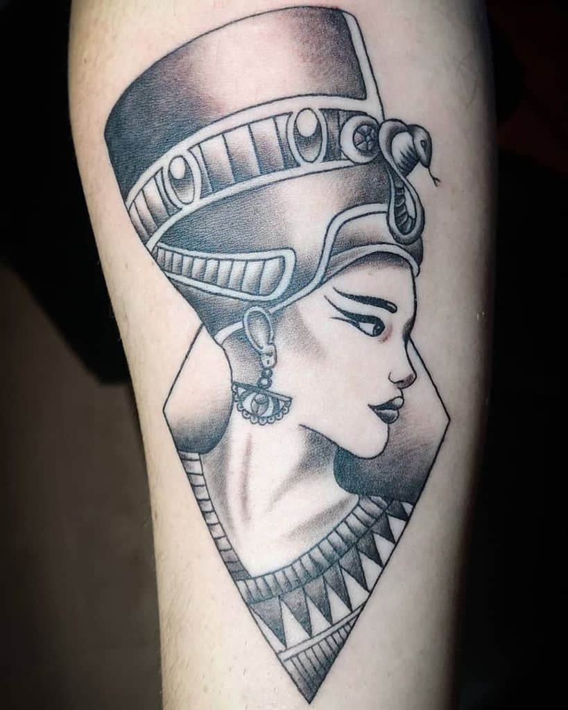 Bold Nefertiti tattoo with detailed shading, a geometric frame, and intricate snake and earring accents