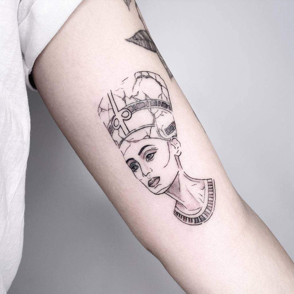Minimalist Nefertiti tattoo design with fine linework and subtle details, showcasing her timeless elegance