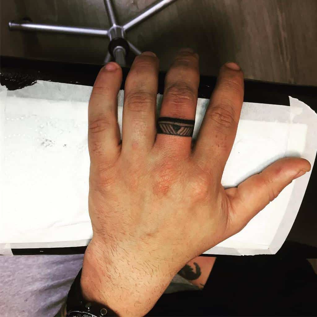 A simple black ink ring tattoo with a black background, straight line and diagonal lines