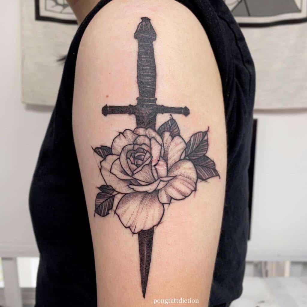 Traditional tattoo of a dagger piercing a rose on an upper arm