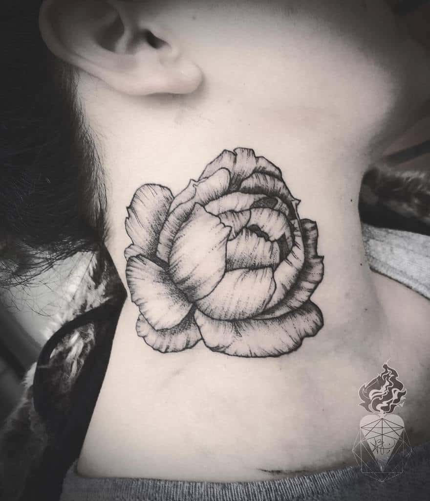 A striking black and white rose tattoo adorns the side of a person's neck, capturing both elegance and boldness