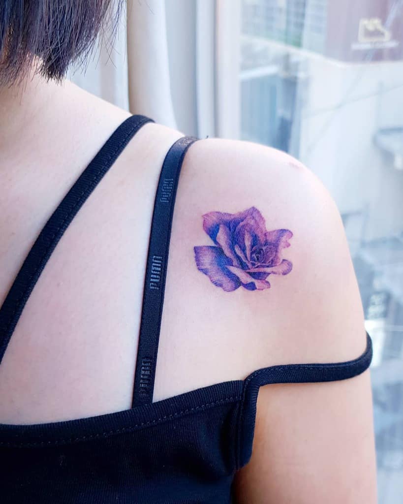 A purple rose tattoo graces the woman's shoulder