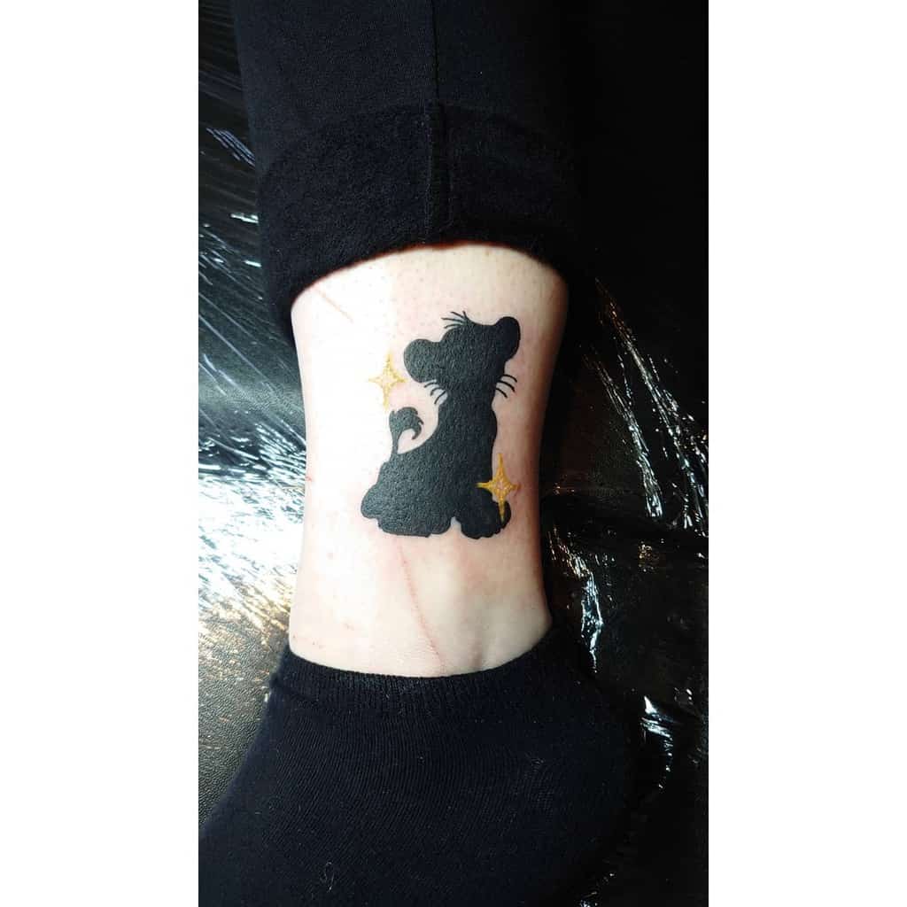 Black silhouette tattoo of Simba as a lion cub with two yellow stars