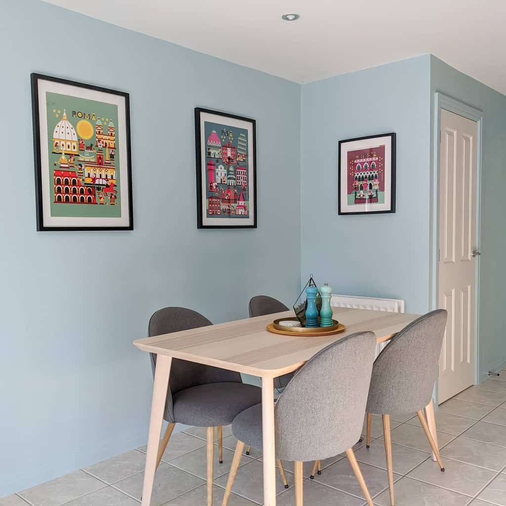 simple blue wall small dining room with framed artwork