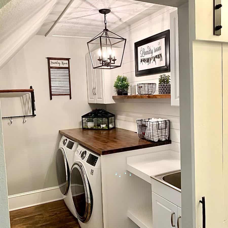 small farmhouse laundry room with shiplap walls and wood shelving