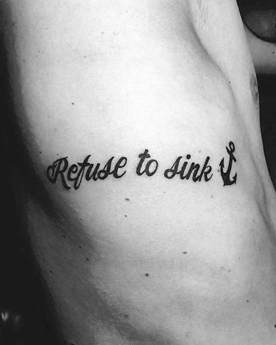 Simple black tattoo of the phrase "Refuse to Sink" in cursive with a small anchor design on the side