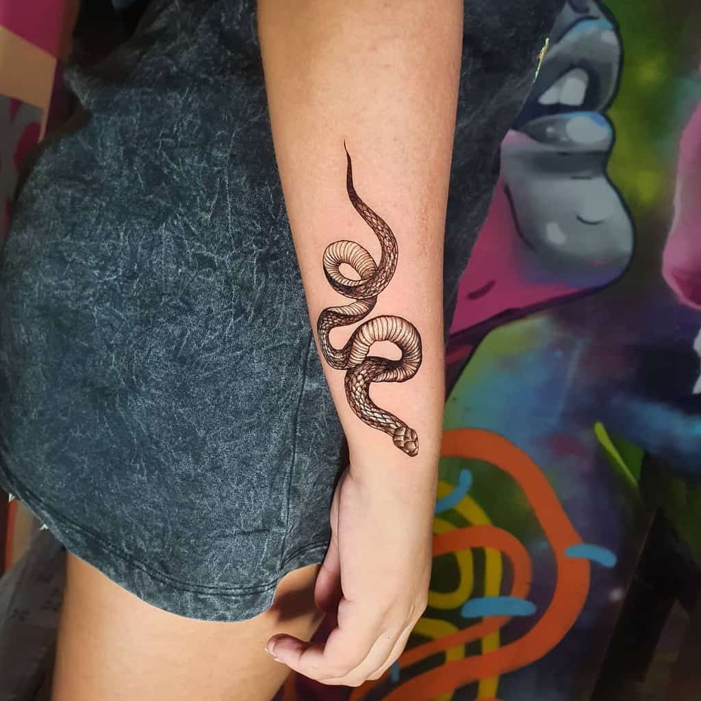 Forearm tattoo of a realistic snake coiled