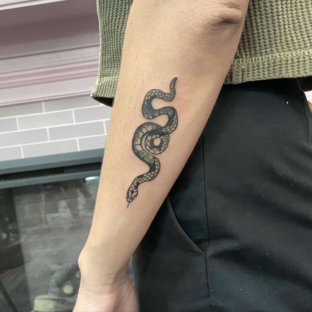 Tattoo of a coiled snake on a forearm,
