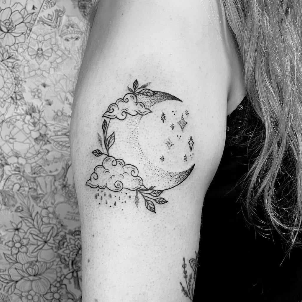 Tattoo of a crescent moon with clouds, stars, and raindrops on a woman's upper arm