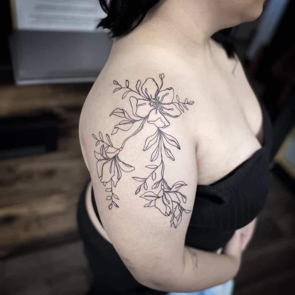 Woman with a large floral outline tattoo on her shoulder and upper arm
