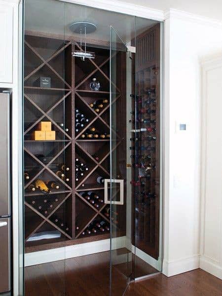 A glass-door wine cellar with wooden racks holds an exquisite assortment of wine bottles and boxes