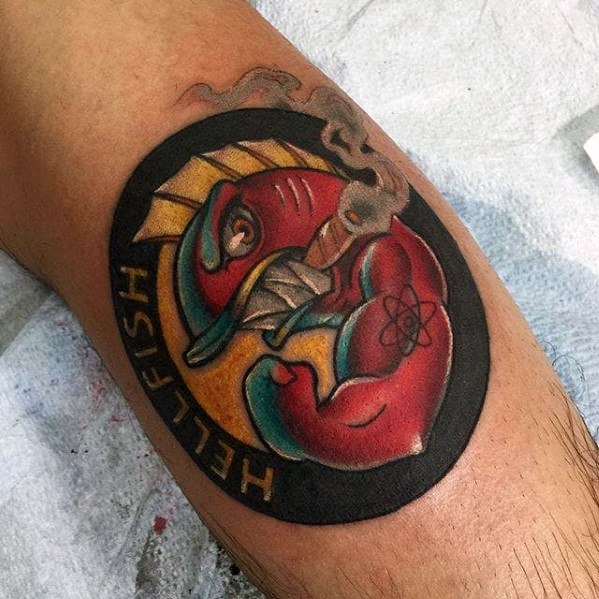 Bold tattoo of the Hellfish logo from The Simpsons, featuring a muscular red fish smoking a cigar inside a black circular background.