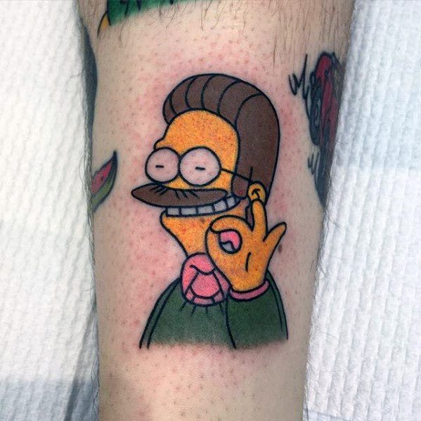 Colorful tattoo of Ned Flanders from The Simpsons making an 'OK' hand gesture with his signature cheerful expression.