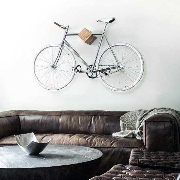 Silver bicycle mounted on a minimalist wooden block wall rack in a modern living room.