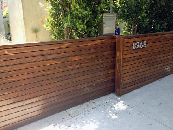 Modern driveway gate with horizontal wood plank design.