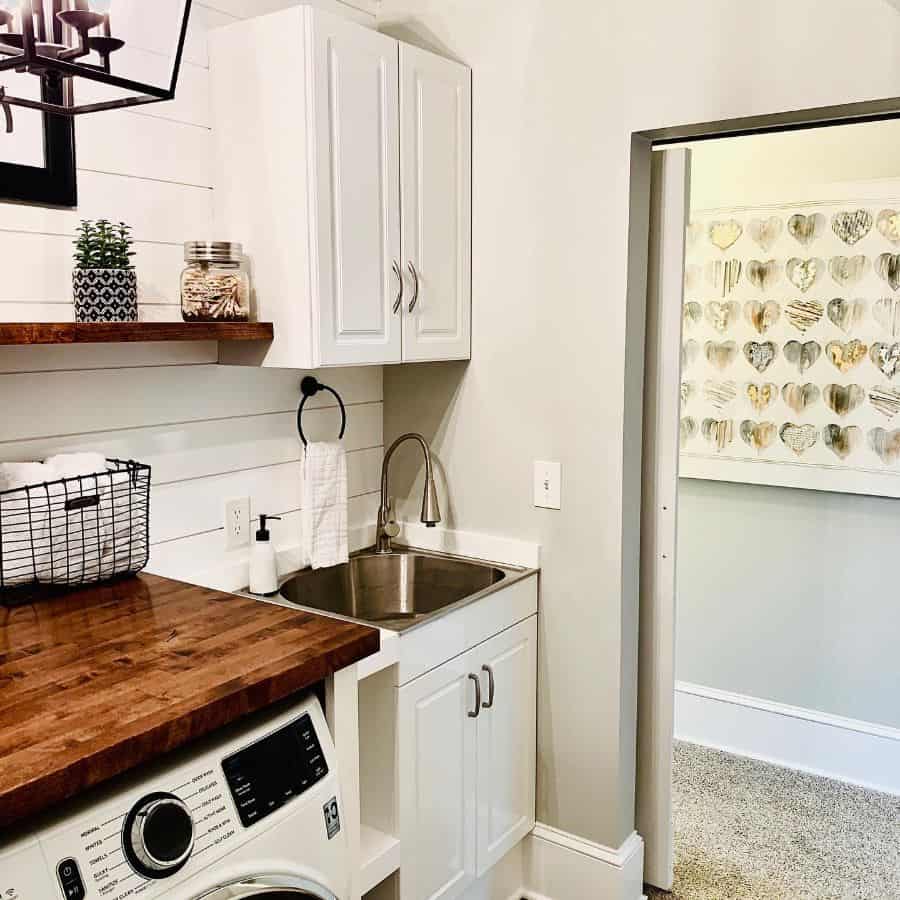 rustic country laundry with white cabinets and standalone sink
