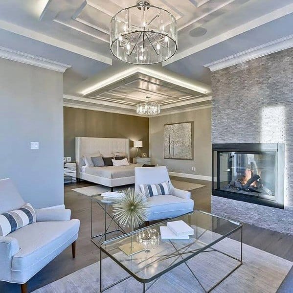 Elegant sitting area in the bedroom with crown molding lighting, a modern fireplace, and stylish furnishings