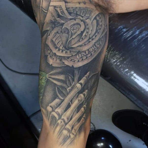 Detailed chest tattoo of a sorrowful religious figure holding a rose, intricately shaded with a money theme woven into the design