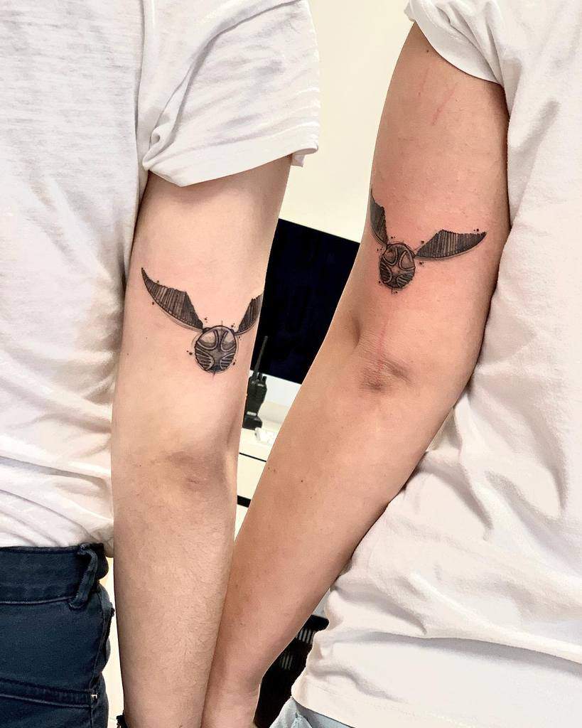 Matching Golden Snitch tattoos, inspired by Harry Potter, symbolizing shared love for Quidditch and magical adventures
