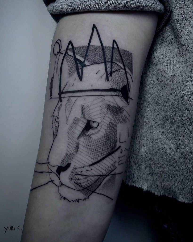 Abstract lioness tattoo on the forearm, featuring bold sketch-style lines, geometric shading, and a minimalist crown for an artistic and modern look.