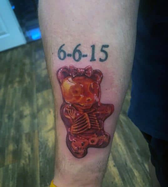 Realistic gummy bear tattoo with an X-ray effect revealing its skeleton, featuring rich shading and a bold, eerie yet playful design.