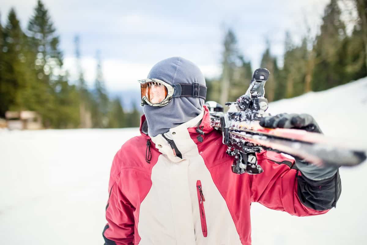 Young,Man,Holding,Ski.skier,Holding,Skis,Looking,At,The,Mountains.side