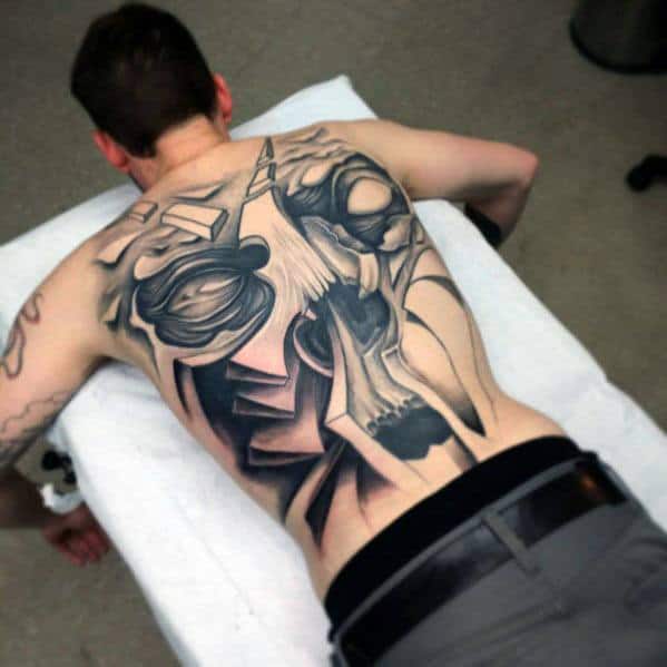 Abstract skull back tattoo with sharp geometric lines, bold shading, and fragmented forms creating a modern, deconstructed look.