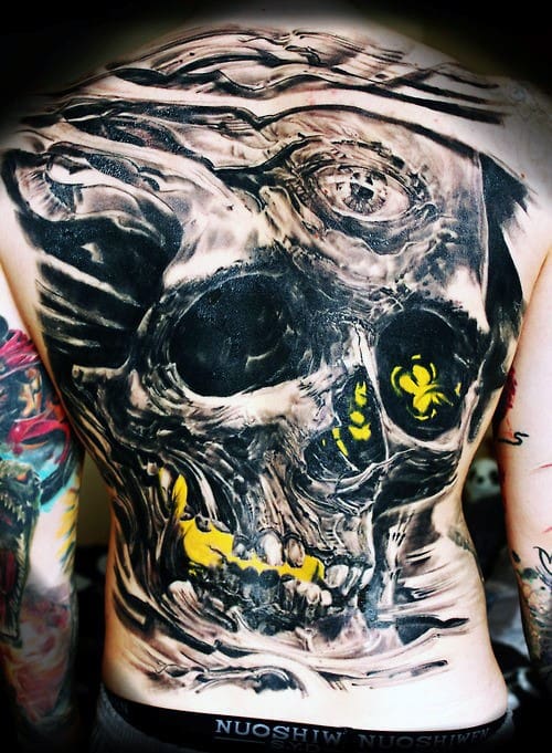 Distorted skull back tattoo with chaotic brushstroke textures, glowing yellow teeth and biohazard symbols, evoking toxicity and decay.