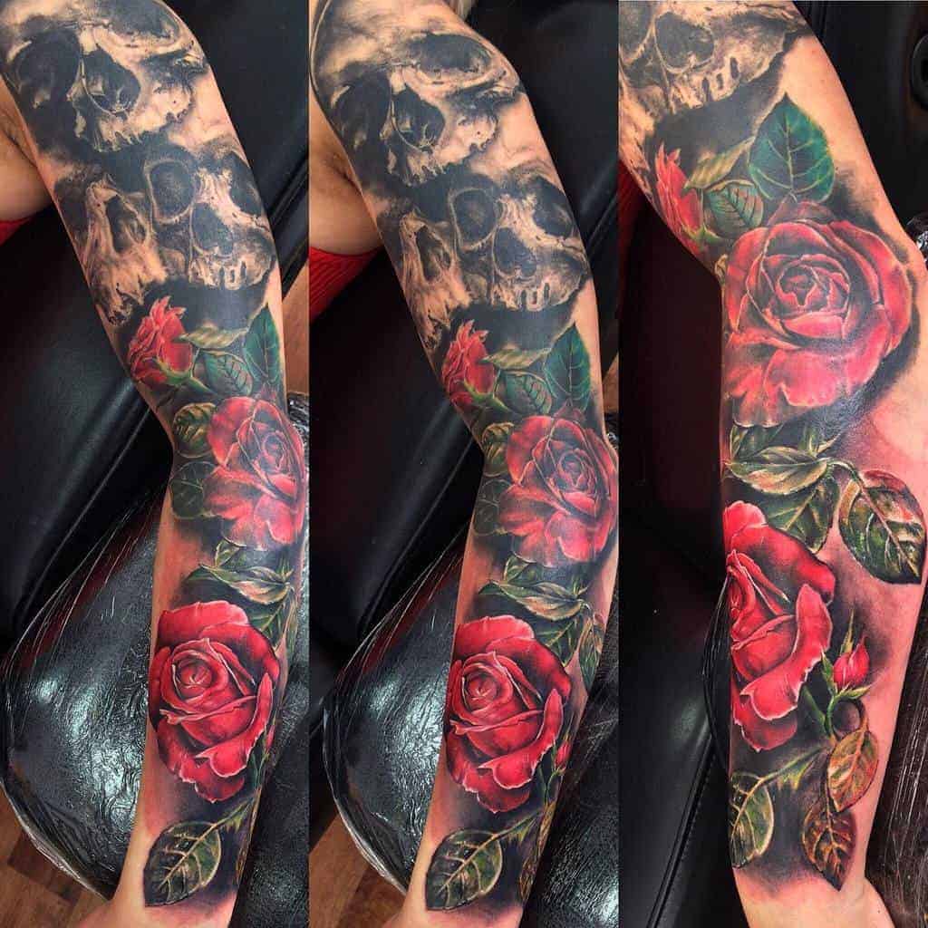 Tattooed arm with red roses and a skull design 