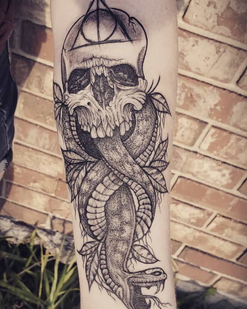 Tattoo of a serpent entwined with a skull and geometric shapes on a forearm