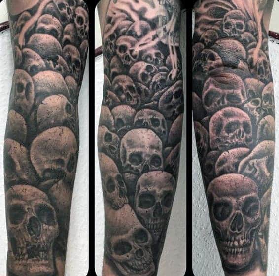 Tattoo sleeve with detailed skulls in dark shading covering entire arm