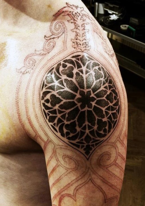 Complex geometric tattoo in progress on a person's upper arm and shoulder