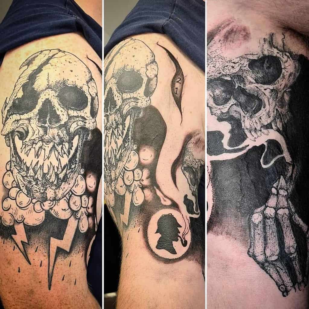 Tattoo of a skull with sharp teeth and shading, featuring clouds, lightning, and profile silhouette elements