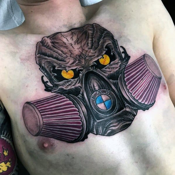 Bold BMW-themed chest tattoo featuring a fierce gas mask design with air filters, glowing eyes, and the BMW logo for a striking look.