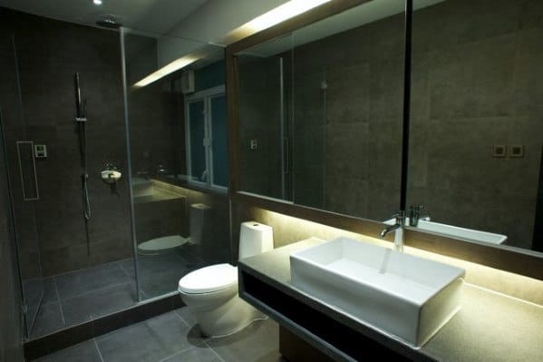 Modern bathroom with a glass shower, large mirror, and square sink on a countertop