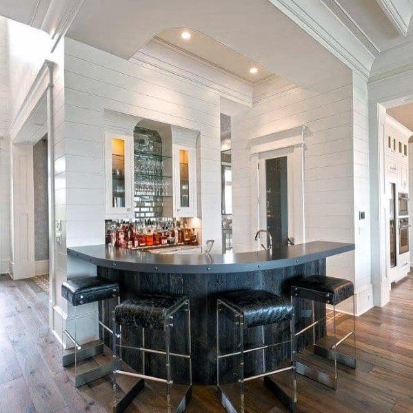 Stylish kitchen with sleek crown molding, a curved bar counter, and modern bar stools, creating an elegant and functional space