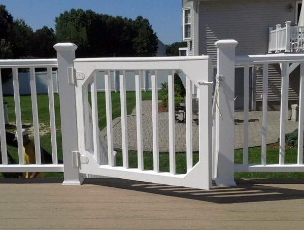 White vinyl gate on the deck, overlooking a grassy yard and part of a house