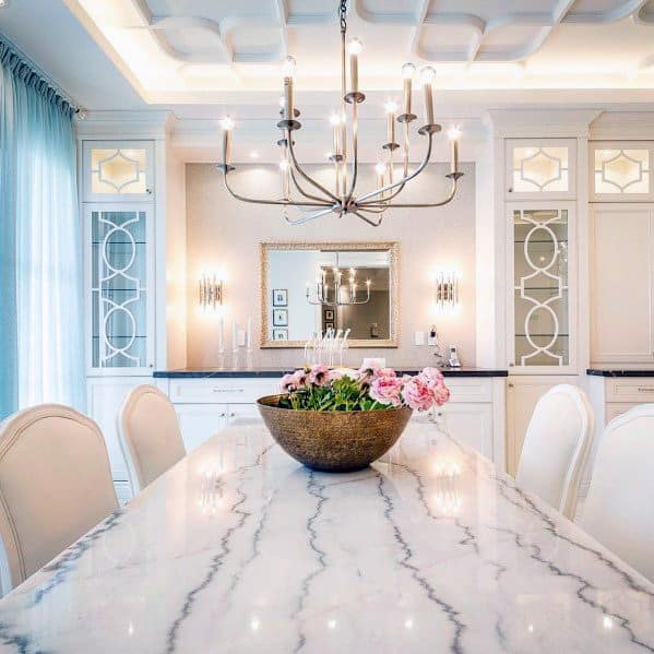 Sleek dining room with white LED crown molding lighting, an elegant chandelier, and a marble dining table