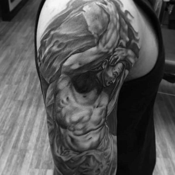 Realistic upper arm Sisyphus tattoo in black and grey, showing a detailed, muscular figure pushing a boulder with intense facial expression.