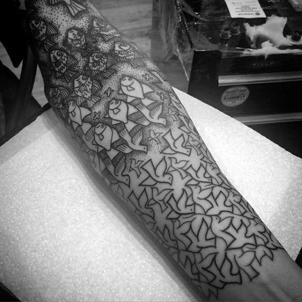 MC Escher-inspired forearm tattoo with fish and bird tessellations transitioning from detailed shading to clean geometric outlines.