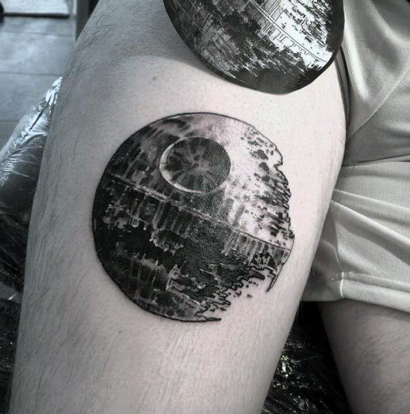 A tattoo of the Death Star on a person's thigh