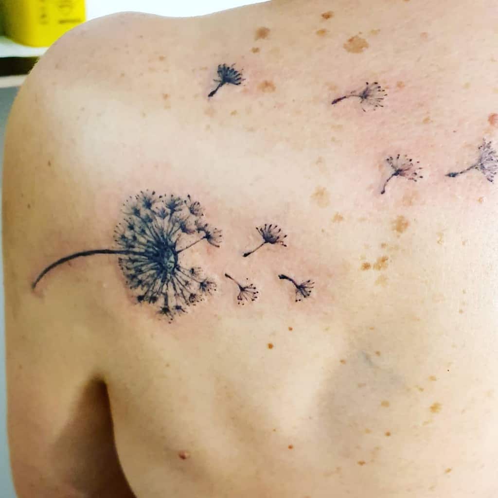 This tattoo beautifully captures a dandelion on the shoulder, with its seeds gently drifting away. The delicate details and soft shading create a light, ethereal effect.