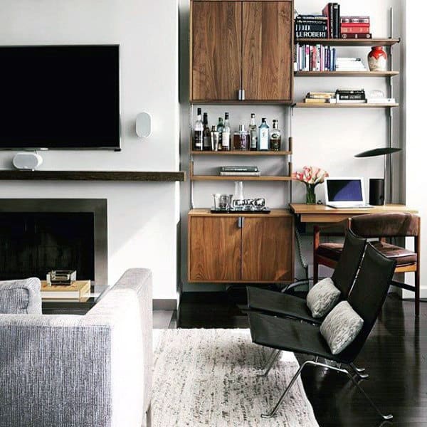 Small modern living room with built-in shelving, home bar, and sleek furniture setup.