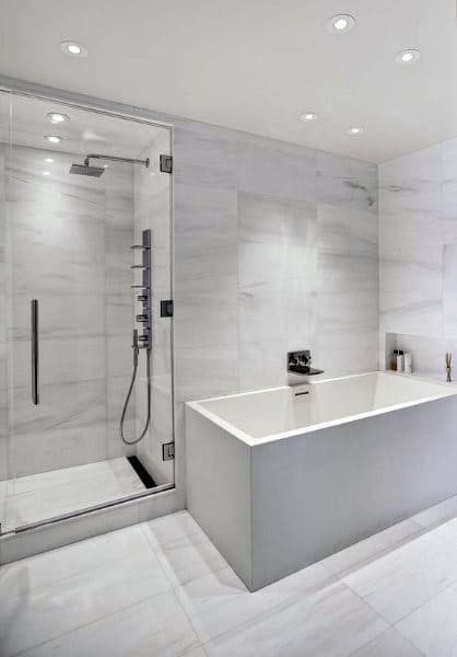 Minimalist white bathroom with a glass-enclosed shower and a rectangular soaking tub.