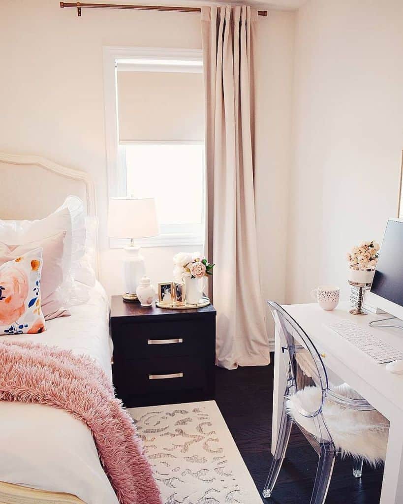 Elegant beige bedroom with white desk, black bedside cabinet, and soft pink accents.