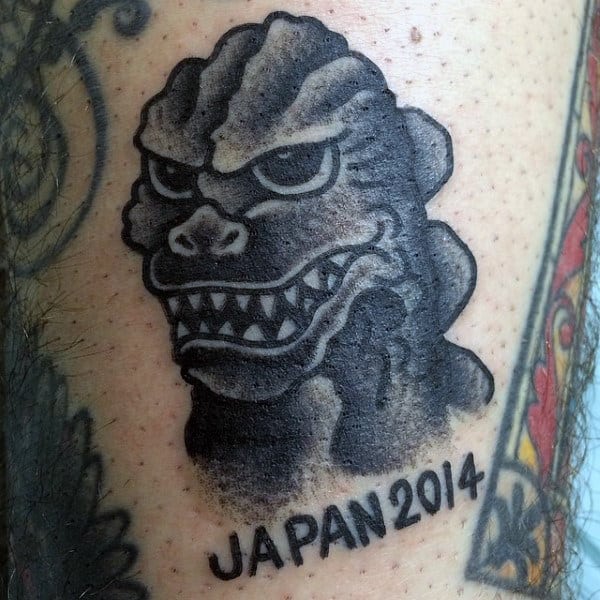 Small Black Shaded Japan Godzilla Portrait Tattoo On Guy